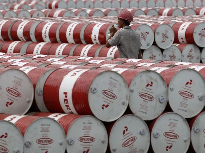 A worker walks in between oil barrels at Pertamina's storage depot in Jakarta in this January 26, 2011 file photo. To match Special Report CHINA-CORRUPTION/INDONESIA REUTERS/Supri/Files (INDONESIA - Tags: ENERGY BUSINESS)