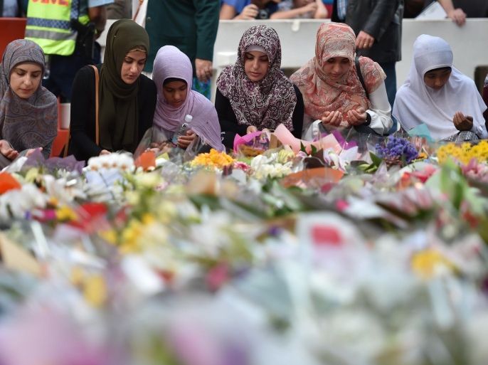 Young Muslim women lay flowers at a makeshift memorial near the scene of a fatal siege in the heart of Sydney's financial district on December 16, 2014. Grieving Australians on December 16 eulogised the victims of the Sydney cafe siege as authorities investigated why its Iranian-born perpetrator had remained at large despite a history of violence and extremism. AFP PHOTO/Peter PARKS