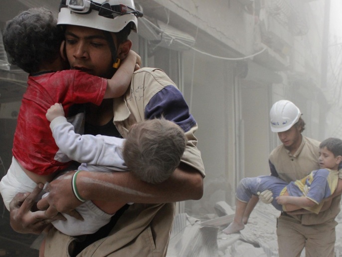 ‪مسعفون خلال إنقاذ أطفال بعد قصف‬ (رويترز-أرشيف)