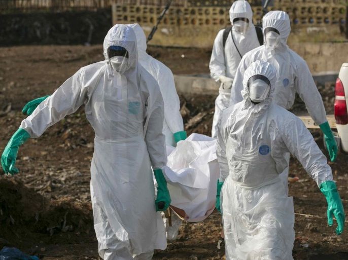 Health workers carry the body of a suspected Ebola victim for burial at a cemetery in Freetown December 21, 2014. REUTERS/Baz Ratner (SIERRA LEONE - Tags: HEALTH DISASTER)