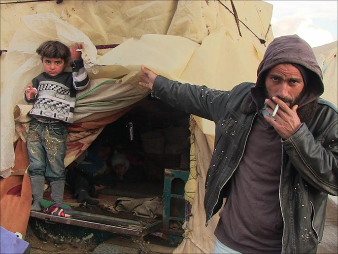 محمود وعائلته يعيشون في سيارتهم بين الحدود السورية التركية (الجزيرة)