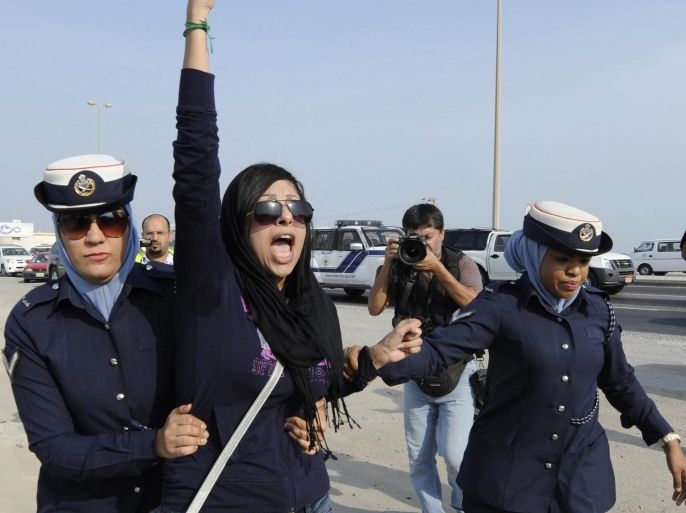 (FILE) A file photograph dated 21 October 2012, shows rights activist Zainab Al-Khawaja (C) reacting as two police women arrest her, during a march toward Eker village, southwest of Manama, Bahrain. According to media reports, Al-Khawaja was released on 14 February 2014 after a year in prison for insulting and humiliating a public employee.