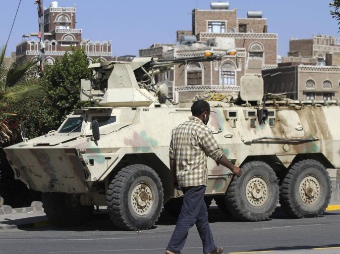 A man walks past an armoured vehicle belonging to Shi'ite Houthi fighters, which was seized from the army recently, near the Defence Ministry compound in Sanaa December 17, 2014. REUTERS/Mohamed al-Sayaghi (YEMEN - Tags: MILITARY CIVIL UNREST)