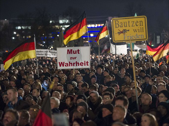 Supporters of the PEGIDA movement, "Patriotische Europaeer Gegen die Islamisierung des Abendlandes," which translates to "Patriotic Europeans Against the Islamification of the Occident," take part in a rally in Dresden, Eastern Germany on December 15, 2014. More than 10,000 people demonstrated against "criminal asylum seekers" and the "Islamisation" of the country, in the latest show of strength of a growing far-right populist movement, according to police. AFP PHOTO / JENS SCHLUETER