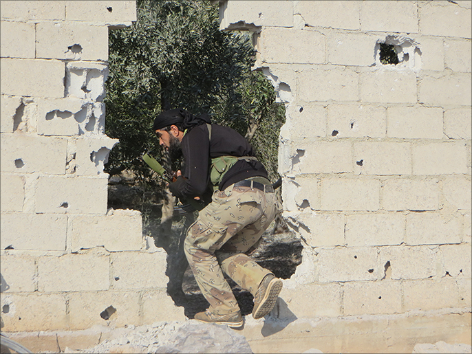 أحد مقاتلي المعارضة أثناء التسلل إلى مواقع للنظام بالشيخ مسكين(الجزيرة)