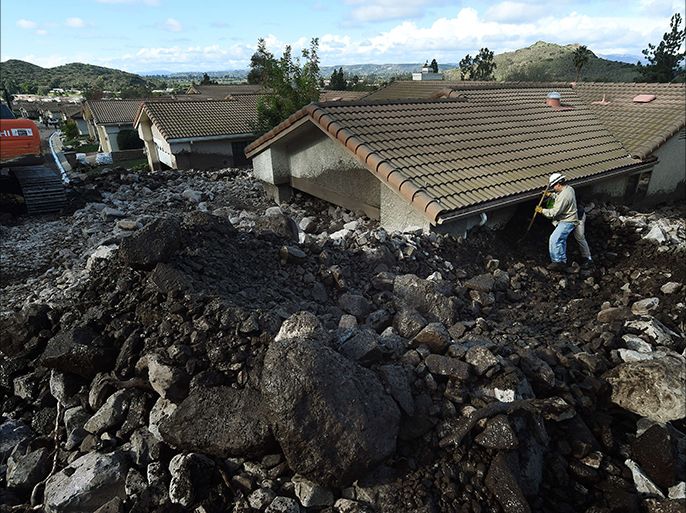 Houses are damaged on San Como Lane after heavy rain triggered a mudslide following a storm in the Camarillo Springs area of Ventura County, California on December 12, 2014. The US Pacific coast's most ferocious storm in years moved south Friday, bringing hurricane force winds and heavy downpours to southern California one day after claiming two lives in the Northwest. AFP PHOTO/MARK RALSTON