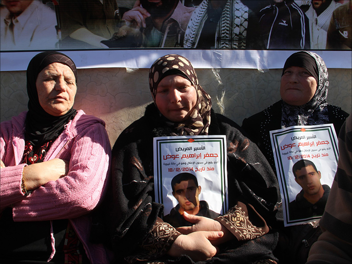 والدة الأسير الفلسطيني جعفر عوض تتوسط امرأتين خلال الاعتصام (الجزيرة)