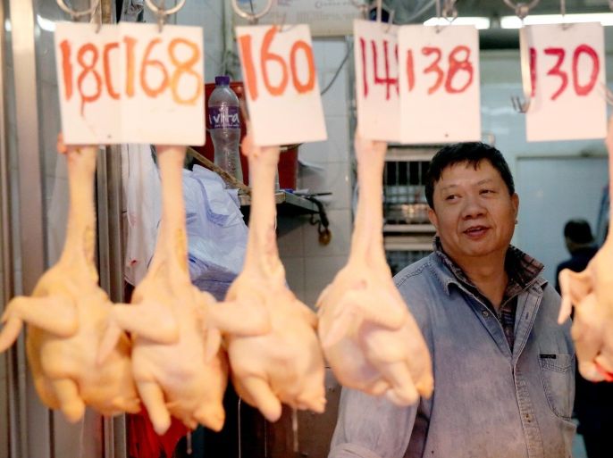 A worker (R) sells chickens at a shop in the Wan Chai district of Hong Kong on December 28, 2014. Hospitals raised alert levels on December 28 as a woman diagnosed with the deadly H7N9 avian flu virus was in a critical condition. AFP PHOTO / ISAAC LAWRENCE