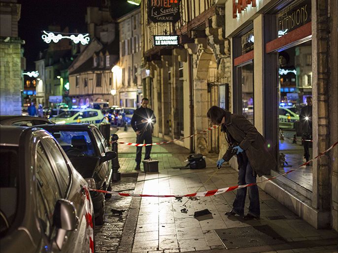 A policewoman collects evidence on December 21, 2014 in Dijon on the site where a driver shouting "Allahu Akbar" ("God is great") ploughed into a crowd injuring 11 people, two seriously, a source close to the investigation said. Two of the people injured in the car attack in the city of Dijon were in a serious condition, a police source said, adding that the driver had been arrested. AFP