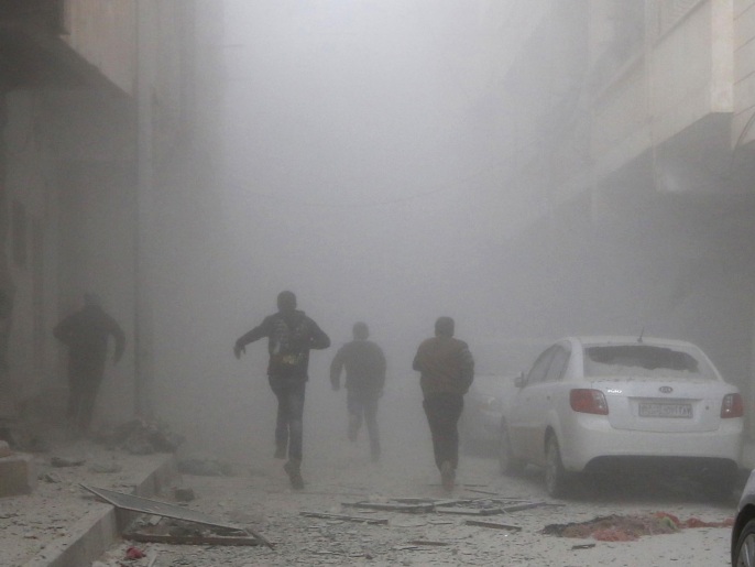 سكان بالرقة يركضون وسط الغبار الناتج عن قصف جوي سابق لقوات النظام 