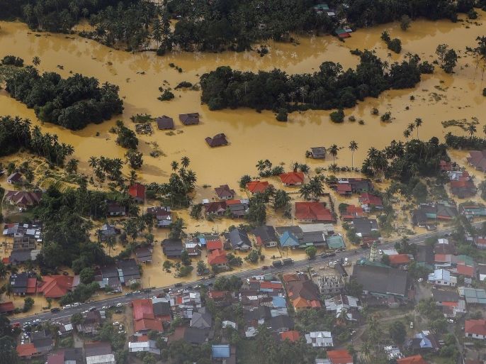 An aerial view of a settlement submerged by floodwaters in the Pengkalan Chepa district of Kelantan, Malaysia, 28 December 2014. The Malaysian government described this flood as the worst in 30 years, at least five people were killed and more than 118,000 people have sought shelter in the hundreds of evacuation centers opened by the government. Malaysian Prime Minister Najib Razak is to cut short a holiday in the United States to deal with major floods at home after coming under fire for spending time golfing with US President Barack Obama in Hawaii during the floods.