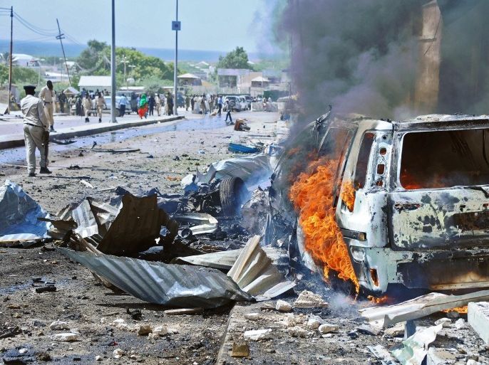 A car burns following a blast near the heavily fortified gates of the airport in Mogadishu on December 3, 2014. At least four people were killed in Somalia's capital Mogadishu when a suicide bomber rammed a car packed with explosives into a UN convoy, police said. The convoy of armoured vehicles were reportedly ferrying staff between Mogadishu's heavily-fortified airport and a protected UN base in the city when it was hit close to the airport gate. AFP PHOTO/Mohamed ABDIWAHAB