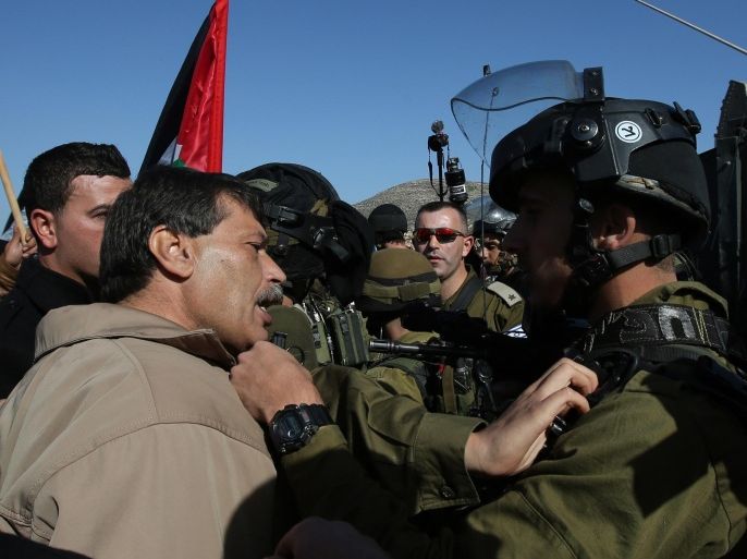 Palestinian official Ziad Abu Ein (L), in charge of the issue of Israeli settlements for the Palestinian Authority, argues with Israeli soldiers during a demonstration in the village of Turmus Aya near Ramallah, on December 10, 2014. The senior Palestinian official died after scuffles with Israeli forces during a protest march in the West Bank, medical and security sources told AFP. AFP PHOTO / ABBAS MOMANI