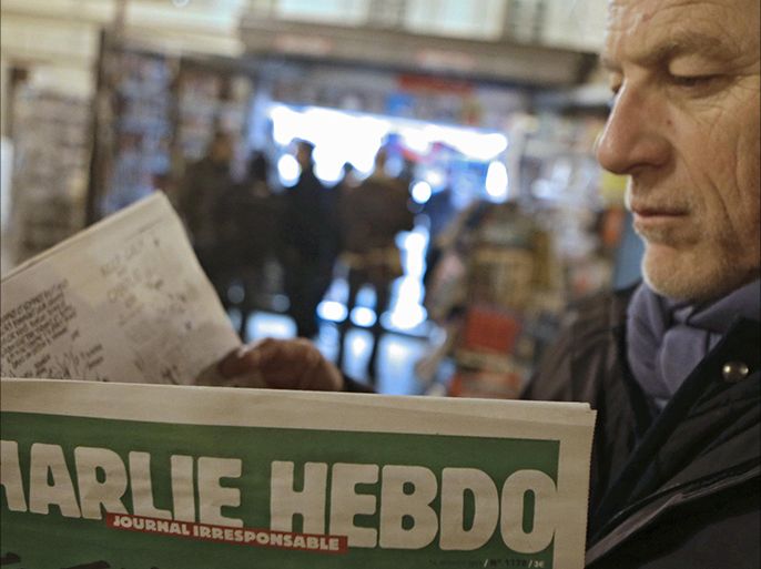 Jean Paul Bierlein reads the latest issue of Charlie Hebdo outside a newsstand in Nice, southeastern France, Wednesday, Jan. 14, 2015.