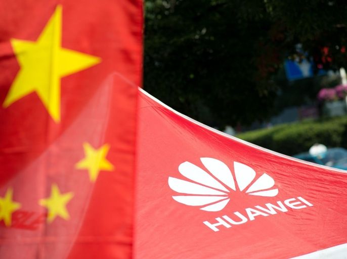 A logo of Huawei Technologies Co Ltd is seen next to a Chinese flag in Shanghai on October 1, 2014. The founder of Chinese telecommunications giant Huawei announced plans to invest 1.5 billion euros ($1.9 billion) in France to develop smartphones, the online edition of Les Echos business daily reported Monday. AFP PHOTO / JOHANNES EISELE