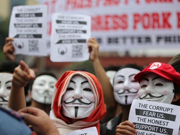 Filipino student protesters wearing masks gesture as they are blocked by police while marching towards the House of Representatives in suburban Quezon city, north of Manila, Philippines on Tuesday Nov. 5, 2013. Supporters of hacker group Anonymous Philippines held the rally to call for the abolition of all forms of "pork barrel" funds after allegations that several members of the House of Representatives and the Philippine Senate conspired with wealthy businesswoman Janet Lim Napoles to steal huge amounts of government development funds. Napoles is set to appear before the Senate Blue Ribbon Committee on Nov. 7.
