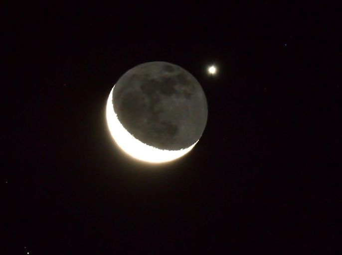 A view of the planet Venus occultation by a thin crescent moon seen over Yangpyeong-gon in Gyeonggi province, South Korea, early 14 August 2012. In an occultation one object (in this case a planet) is briefly hidden behind another object.