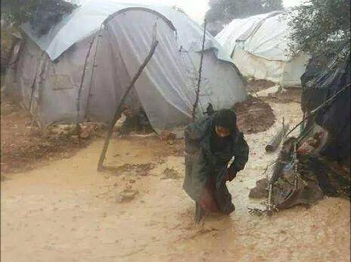 طفلة تخوض في وحل المخيم في ريف إدلب