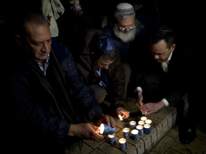 Israelis, mostly French Jews light candles as they gather to pay tribute to victims of the attack on kosher grocery store in Paris where four hostages were killed on Friday, in Tel Aviv, Israel, Saturday, Jan. 10, 2015. Israel's Prime Minister Benjamin Netanyahu says he will try to increase immigration of French Jews and others in Europe suffering from a "rising tide of anti-Semitism." Netanyahu's comments Saturday came a day after four French Jews were killed inside a kosher market in Paris. Netanyahu said every Jew who wanted to move to Israel would be "welcomed with a warm heart and open arms. (AP Photo/Oded Balilty)
