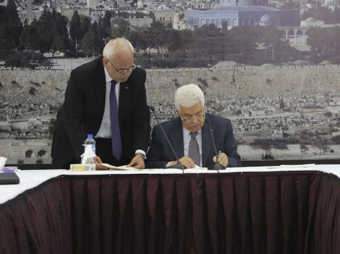 Palestinian President Mahmoud Abbas (R) signs international agreements in the West Bank city of Ramallah, in this December 31, 2014 handout picture. Abbas signed on to 20 international agreements on Wednesday, including the Rome Statute of the International Criminal Court, a day after a bid for independence by 2017 failed at the United Nations Security Council. REUTERS/Osama Falah/Palestinian President Office (PPO)/Handout via Reuters (WEST BANK - Tags: POLITICS) ATTENTION EDITORS - THIS PICTURE WAS PROVIDED BY A THIRD PARTY. REUTERS IS UNABLE TO INDEPENDENTLY VERIFY THE AUTHENTICITY, CONTENT, LOCATION OR DATE OF THIS IMAGE. NO SALES. NO ARCHIVES. FOR EDITORIAL USE ONLY. NOT FOR SALE FOR MARKETING OR ADVERTISING CAMPAIGNS. THIS PICTURE IS DISTRIBUTED EXACTLY AS RECEIVED BY REUTERS, AS A SERVICE TO CLIENTS