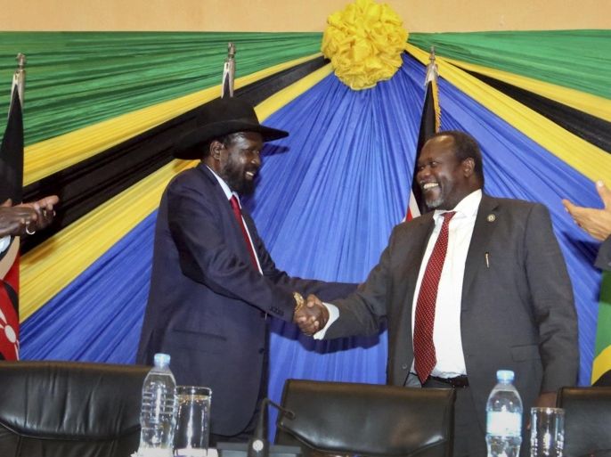 In this photo taken Wednesday, Jan. 21, 2015, South Sudan's President Salva Kiir, left, shakes hands with rebel leader and former vice president Riek Machar, right, after signing an agreement at the end of talks in Arusha, Tanzania. South Sudan's warring factions have agreed to reunify their political party, a conflict resolution organization said Thursday, with South Sudan President Salva Kiir and rebel leader Riek Machar signing the agreement to unite the ruling Sudan People's Liberation Movement on Wednesday in the Tanzanian town of Arusha, according to the Conflict Management Initiative. (AP Photo)