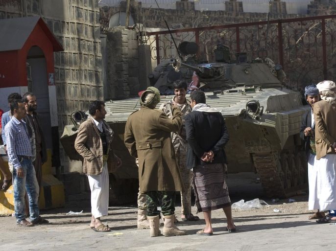 People and Houthi Shiite Yemeni wearing army uniforms stand near an armored vehicle, which was seized from the army during recent clashes, outside the house of Yemen's President Abed Rabbo Mansour Hadi in Sanaa, Yemen, Thursday, Jan. 22, 2015. Heavily armed Shiite rebels remain stationed outside the Yemeni president's house and the palace in Sanaa, despite a deal calling for their immediate withdrawal to end a violent standoff. (AP Photo/Hani Mohammed)