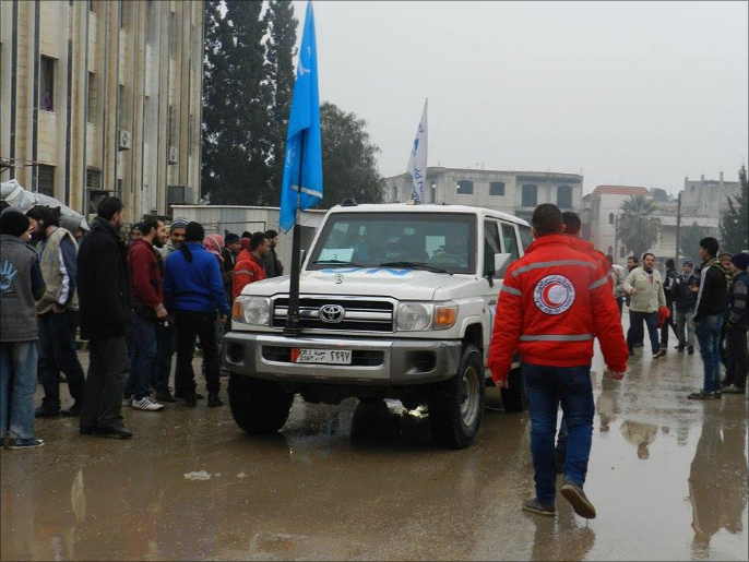سيارات الأمم المتحدة داخل حي الوعر بحمص (الجزيرة نت)