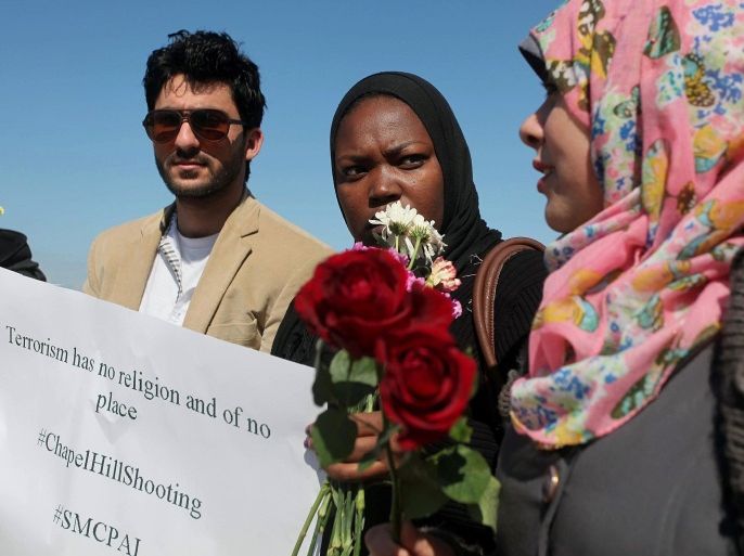 GAZA CITY, GAZA - FEBRUARY 14: A group of Palestinian hold banners and flowers on the Gaza shore on February 14, 2015 to remember of the three Muslim students who were shot dead in Chapel Hill, North Carolina. Muslim students Deah Barakat, 23, his wife Yusor Mohammad Abu-Salha, 21, and her sister Razan Mohammad Abu-Salha, 19, were shot dead at their home on February 10,2015 in Chapel Hill, North Carolina.