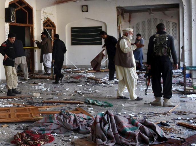 Pakistani security personnel inspect a Shiite Muslim mosque after an attack by Taliban militants in Peshawar on February 13, 2015. Grenade-toting Taliban militants stormed a Shiite mosque in northwest Pakistan, police said, in an attack that left at least 18 people dead. AFP PHOTO / A MAJEED
