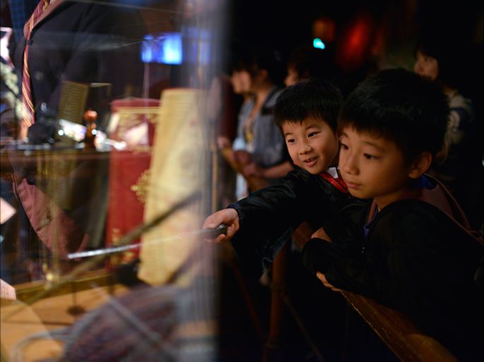 epa03752762 Young Japanese Harry Potter fans look at a display during the preview of the Harry Potter exhibition in Tokyo, Japan, 20 June 2013. The exhibition displaying costums and objects used in the Harry Potter movies will open to the public from 22 June to 16 September. EPA/FRANCK ROBICHON