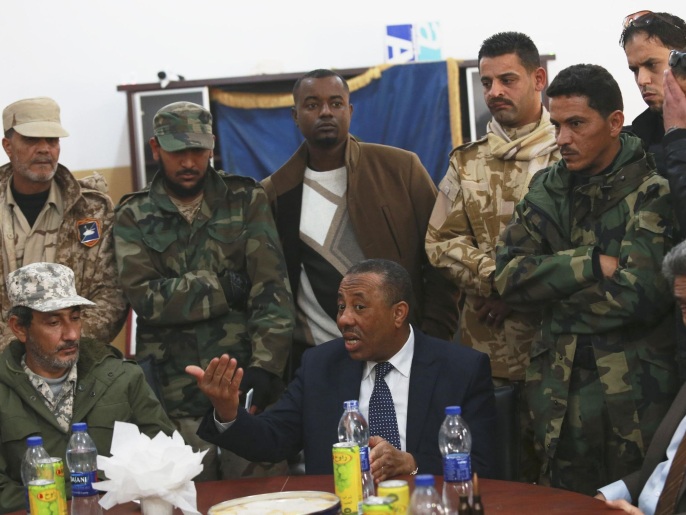 عبد الله الثني بين مجموعة من العسكريين أثناء زيارته بنغازي الأحد الماضي (رويترز)