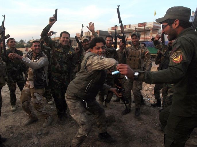 Iraqi Shiite fighters celebrate on February 2, 2015 in al-Mansuriya, in Iraq's Diyala province, after government forces retook the area from Islamic State group's control. Iraqi forces have 'liberated' Diyala province from the Islamic State jihadist group, retaking all populated areas of the eastern region. The symbolic victory for Baghdad, which has at times struggled to push IS back, could clear the way for further advances against the jihadists. AFPPHOTO/AHMAD AL-RUBAYE