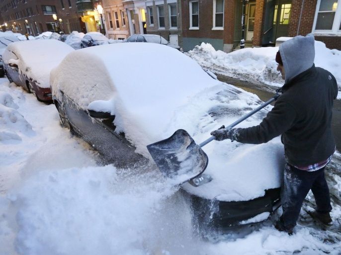 Alex Ranere, of Boston, uses a shovel to remove snow from his car, Sunday, Feb. 8, 2015, in Boston's North End neighborhood. Winter weary New England is being hit with a protracted snowstorm that started Saturday night and could last until early Tuesday morning. (AP Photo/Steven Senne)