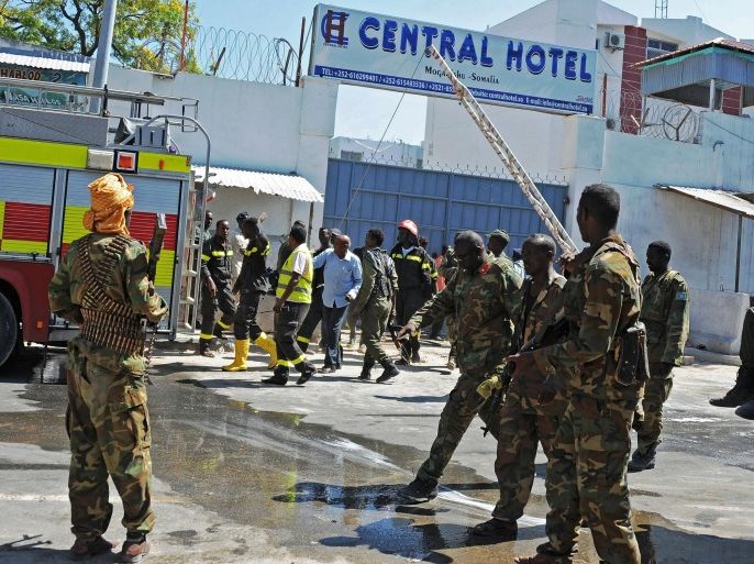 Somali security forces, paramedics and firefighters stand outside the Central Hotel, close to the presidential palace, in Mogadishu on February 20, 2015. Somalia's Al-Qaeda-linked Shebab insurgents killed at least 25 people today in an attack on a popular hotel in the capital Mogadishu where government ministers and officials were holding Friday prayers. AFP PHOTO / MOHAMED ABDIWAHAB