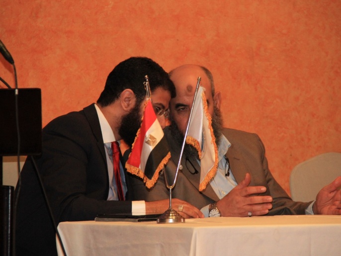 يونس مخيون رئيس حزب النور ومساعده نادر بكار في حديث جانبي بأحد المؤتمرات (الجزيرة)