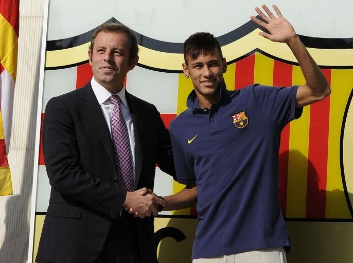 BARCELONA, SPAIN - JUNE 03: C Barcelona President Sandro Rosell and Neymar shake hands as they pose for the media during the official presentation as a new player of the FC Barcelona sports complex on June 3, 2013 in Barcelona, Spain.