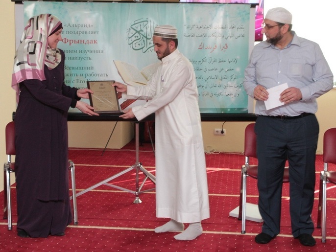‪إيمان تتسلم جائزة من المركز الإسلامي بعد أن أتمت حفظ القرآن‬ (الجزيرة)