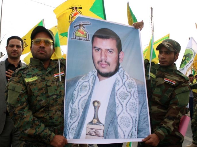Iraqi supporters of the Hezbollah hold up the yellow flags of the Iraqi branch of the Shiite Muslim party and a portrait of Shiite Huthi rebels' leader in Yemen, Abdulmalik al-Huthi, during a demonstration to protest against the Saudi-led Arab coalition which is carrying out air strikes on Huthi militia targets across Yemen on March 31, 2015 in the mainly Shiite southern Iraqi city of Basra. AFP PHOTO / HAIDAR MOHAMMED ALI