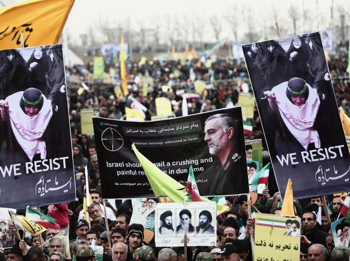 Iranian demonstrators hold a portrait of Iranian commander Major General Qassem Suleimani (C), who has been advising Iraqi military leaders fighting Islamic jihadists,during a rally to mark the 36th anniversary of the Islamic revolution in Tehran's Azadi Square (Freedom Square) on February 11, 2015. President Hassan Rouhani delivered a speech saying said the world needs Iran to help stabilise the troubled Middle East, in remarks pointing to wider ramifications of a deal over its disputed nuclear programme. AFP PHOTO/BEHROUZ MEHRI
