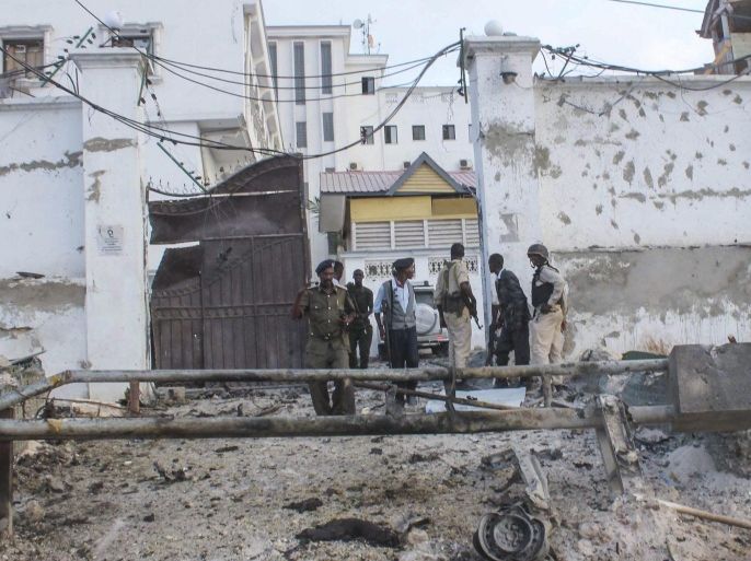 Somali security officers stand guard at the scene of a car bomb explosion in front of a hotel in Mogadishu, Somalia, 27 March 2015. Reports say that a car bomb explosion followed by gunfire at a popular hotel in Mogadishu killed at least several people on 27 March. No one has claimed responsibility though scuh attacks in Mogadishu are often carried out by Islamist militant group al-Shabab.