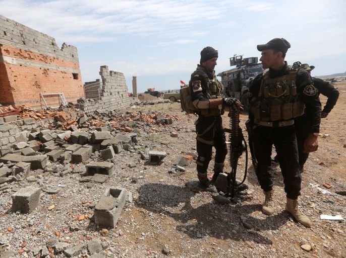 Iraqi security forces gather next to a damaged house in the southern entrance of the city of Tikrit on March 29, 2015 during a military operation to retake the northern Iraqi city from Islamic State (IS) group jihadists. IS spearheaded a sweeping offensive last June that overran much of Iraq's Sunni Arab heartland, and the operation to retake Tikrit is Baghdad's largest to date against the militants. AFP PHOTO / AHMAD AL-RUBAYE
