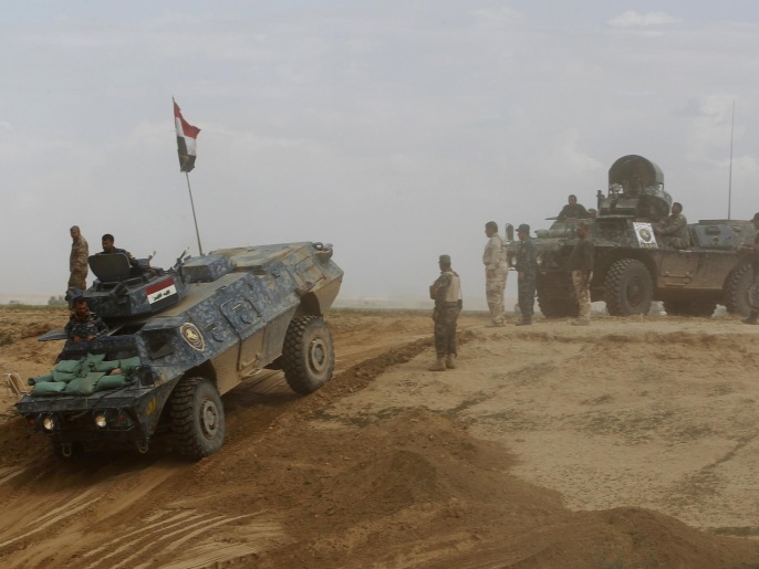قوات عراقية ومسلحون من فصائل شيعية في بلدة حمرين بمحافظة صلاح الدين (رويترز)