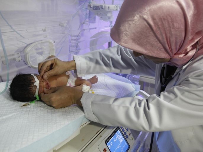 Pediatrician Samira al-Alani examines a child with a cleft lip in an incubator in a Falluja hospital, 50 km (31 miles) west of Baghdad, August 26, 2013. Alarmed by a rise in congenital anomalies in her city of Falluja, al-Aani launched a petition calling on the World Health Organisation (WHO) to release what she says are data collected more than a year ago on birth defects rates caused by the US-led 2003 war on Iraq for independent analysis. Picture taken August 26, 2013. REUTERS/Saad Shalash (IRAQ - Tags - Tags: HEALTH CONFLICT)