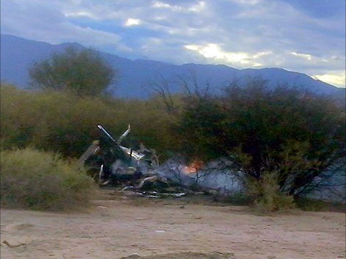 Picture of the burning wreckages of two helicopters which collided mid-air near Villa Castelli, in the Argentine province of La Rioja, on March 9, 2015. Eight French nationals, including sports stars, filming a reality TV show were killed Monday along with two Argentine pilots when their helicopters collided in mid-air in northwestern Argentina, officials said. AFP PHOTO / ALDO PORTUGAL --- ALTERNATIVE CROP - BEST QUALITY AVAILABLE