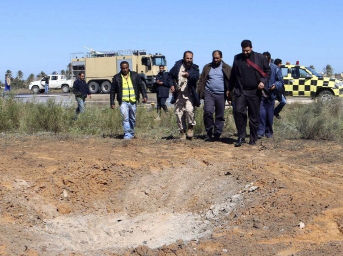 Members of the airport security and civil aviation officials examine the scene after an airstrike hit Tripoli's Maitiga airport March 3, 2015. Rival Libyan forces carried out tit-for-tat air strikes on oil terminals and an airport on Tuesday, escalating their battle for control of the oil-producing country days before United Nations peace talks are to resume in Morocco. REUTERS/Hani Amara (LIBYA - Tags: POLITICS CIVIL UNREST TRANSPORT)