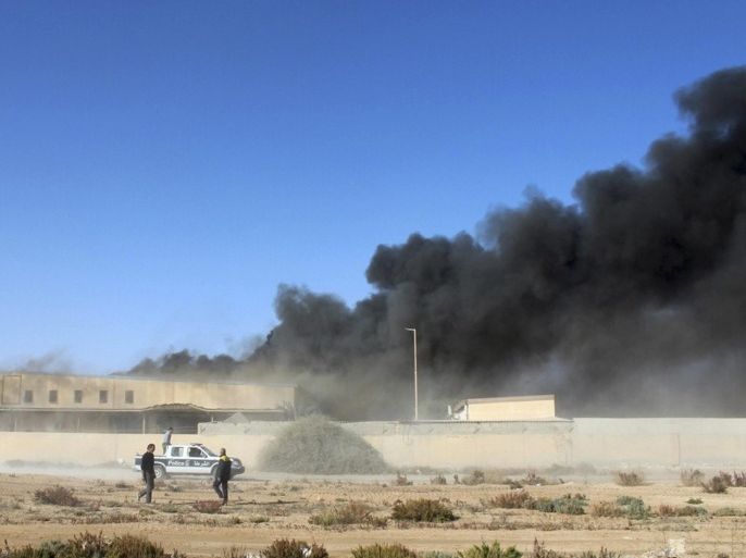 Black smoke billows from a warehouse after an airstrike in Zawura, December 2, 2014. At least three people were killed on Tuesday in air strikes on a town west of Tripoli carried out by forces loyal to Libya's internationally recognised government, which is in conflict with a rival force controlling the capital, officials said. The strikes targeted three locations in the Zawura city, including a food supply storage area, a fishing port and another unspecified target outside of the city, according to the local authorities and a military official. REUTERS/Stringer (LIBYA - Tags: CIVIL UNREST POLITICS)