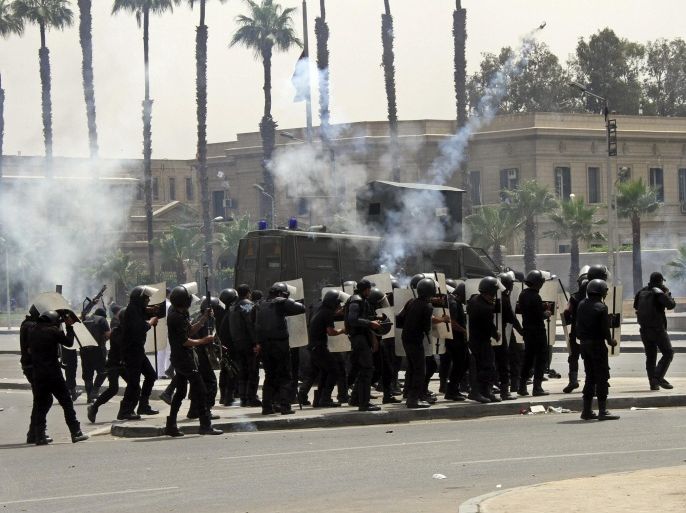FILE - In this file photo taken Monday, May 20, 2014, riot police fire tear gas towards supporters of the Muslim Brotherhood during a demonstration at Cairo University hours after a drive-by shooting killed several Egyptian policemen and wounded others during an overnight rally by Islamist students at another university, in Cairo, Egypt. Summer vacation ends this second weekend of October, and universities across Egypt are preparing for the return of students with a heavy, pre-emptive clampdown. The aim is to prevent a resurgence of protests by supporters of Mohammed Morsi, the Islamist president who was removed by the military just over a year ago. (AP Photo/Ahmed Gamil, File)