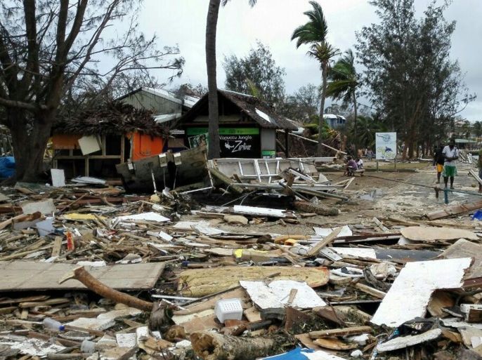 In this photo provided by China's Xinhua News Agency, locals walk past debris in Port Vila, Vanuatu, after Cyclone Pam ripped through the tiny South Pacific archipelago, Sunday, March 15, 2015. Packing winds of 270 kilometers (168 miles) per hour, Cyclone Pam tore through Vanuatu early Saturday, leaving a trail of destruction. (AP Photo/Xinhua, Luo Xiangfeng) NO SALES