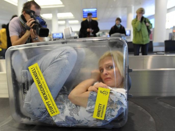 A woman is locked up in a transparent suitcase reading "Stop Human Trafficking! 60 Years of Human Rights" on a luggage belt at the airport in Munich, southern Germany, on December 11, 2008. The Human Rights organisation Amnesty International staged the action commemorate the 60th anniversary of the Universal Declaration of Human Rights by the United Nations. Based on France's 1789 Declaration of the Rights of Man and the 1776 US Declaration of Independence, the 30-point non-binding text of the declaration was initially adopted by 58 states, with World War II's atrocities fresh in their minds. "All human beings are born free and equal in dignity and rights," proclaimed Article 1 of the text. "Stoppt Menschenhandel" steht am Donnerstag (11.12.08) auf einem Gepaeckband auf dem Flughafen Muenchen (Bayern) auf einem durchsichtigen Koffer in dem sich eine Frau befindet. Amnesty International feiert das 60-jaehrige Bestehen der Menschenrechte. Unter dem Motto �Ich schuetze Sie � Sie schuetzen mich� fand am Muenchner Flughafen eine plakative Aktion gegen den �Menschenhandel� statt. Foto: Oliver Lang/ddp.
