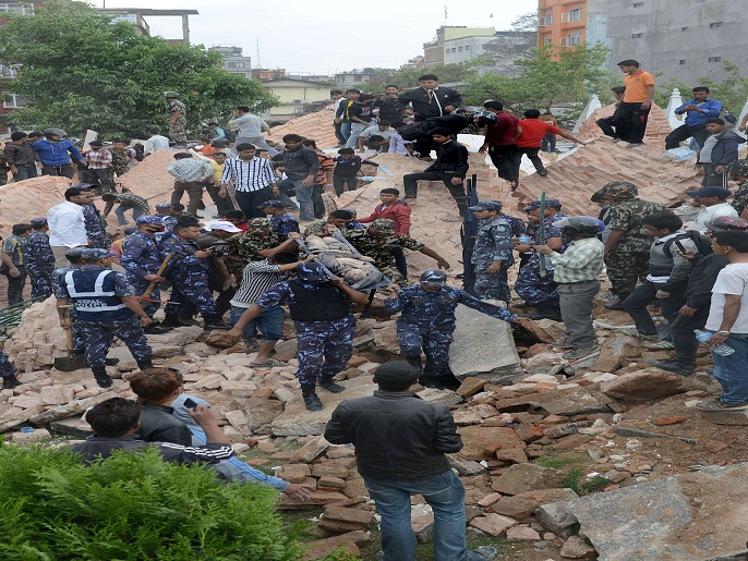 فرق الإنقاذ في نيبال تحاول إخراج الضحايا من تحت الأنقاض بعد الزلزال المدمر (الفرنسية)